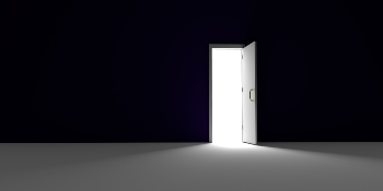 Light spills into a dark room. Open door between light and darkness